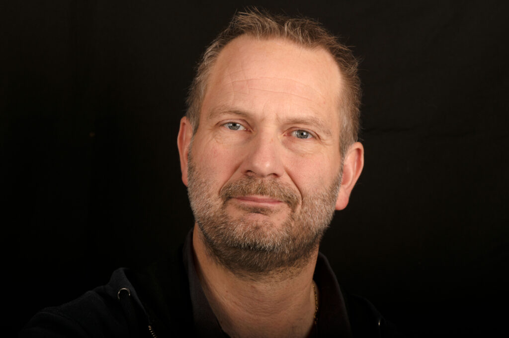 Robert Vestergaard, portræt mod sort baggrund